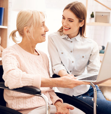 female caregiver with senior woman smiling and laughing at each other