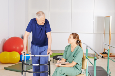 woman assisting senior man having physical therapy